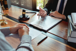 Lawyer working with client discussing contract papers with brass scale about legal legislation in courtroom, consulting to help their customer prepare for deposition process