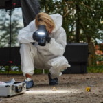 woman investigator at a crime scene taking photos of evidence to use in trial exhibit