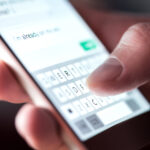 Man sending text message and sms with smartphone. Guy texting and using mobile phone late at night in dark. Communication or sexting concept. Finger typing with cellphone keyboard. Light from screen. can text messages be used in court