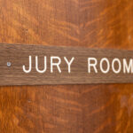 sign on a wooden door that says jury room