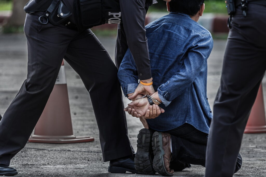 police putting a man in handcuffs for a crime