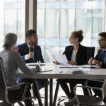 group of lawyers sitting around a conference room table discussing litigation support services for their client