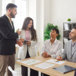 Diverse joyful people chatting on business meeting. Company employees talking in office and making great decisions for how to select litigation support services