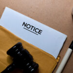 Notice of deposition in brown envelope and judges gavel. Justice and Law Concept