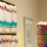 stack of medical records folders for medical record review for attorneys